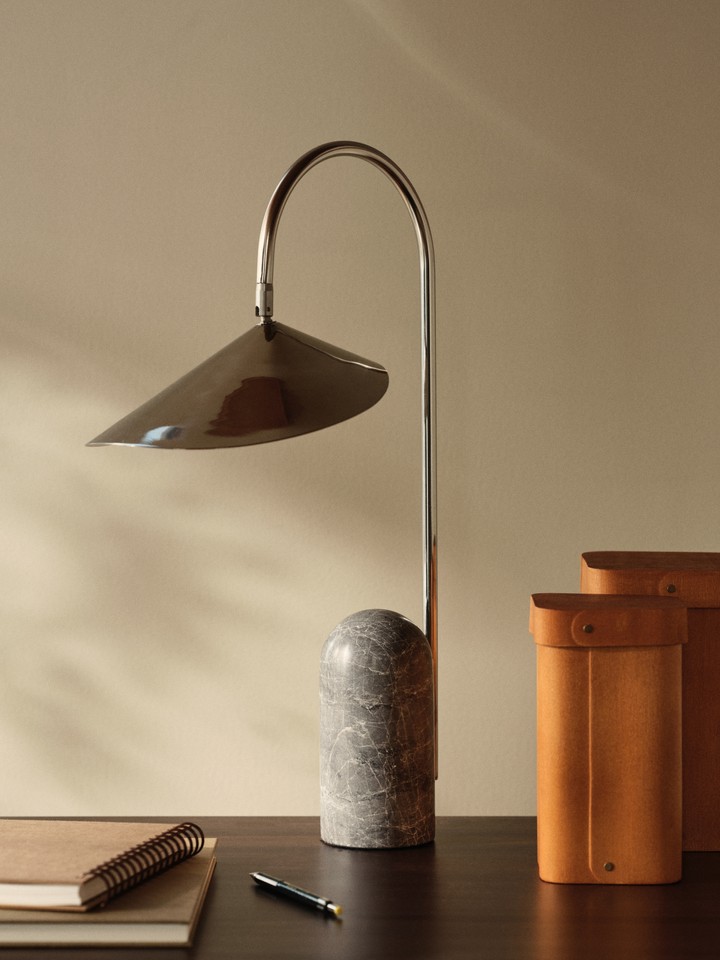 Arum bordlampe i rustfritt stål på et skrivebord